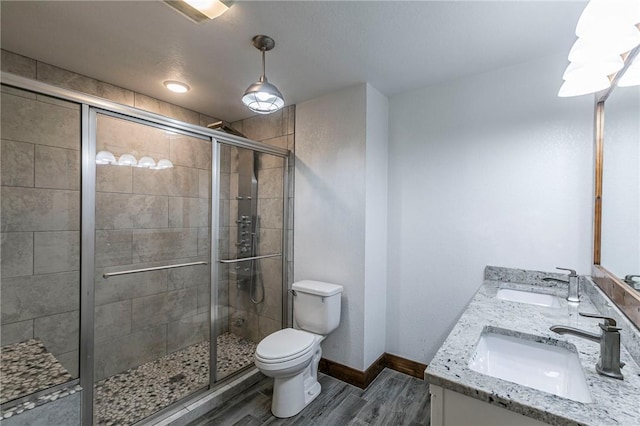 bathroom featuring hardwood / wood-style flooring, vanity, toilet, and an enclosed shower