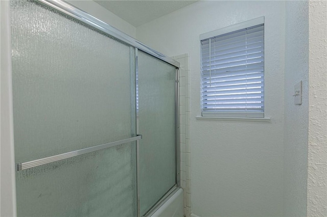 bathroom with shower / bath combination with glass door