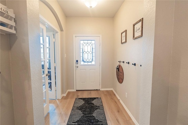 entryway with light wood finished floors and baseboards