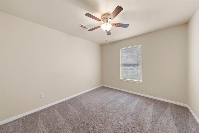 spare room with baseboards, visible vents, carpet floors, and ceiling fan