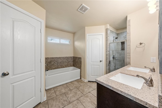 bathroom with a garden tub, visible vents, a tile shower, and a sink