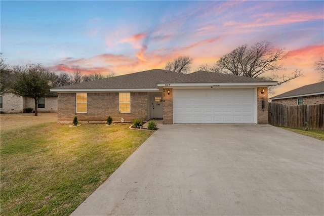 ranch-style house with driveway, fence, a yard, a garage, and brick siding