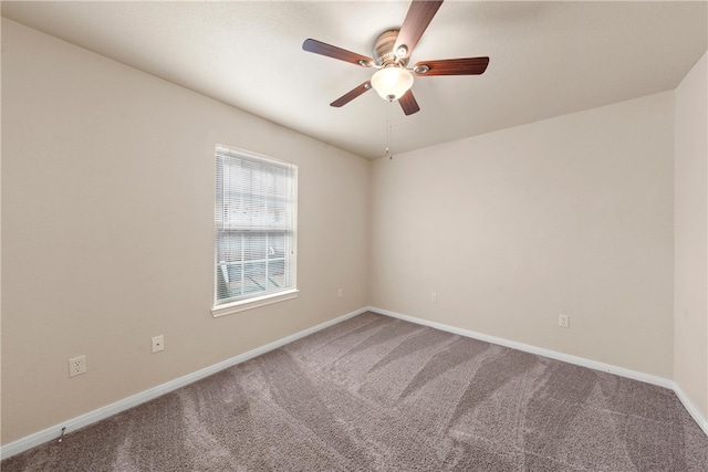 carpeted empty room featuring a ceiling fan and baseboards