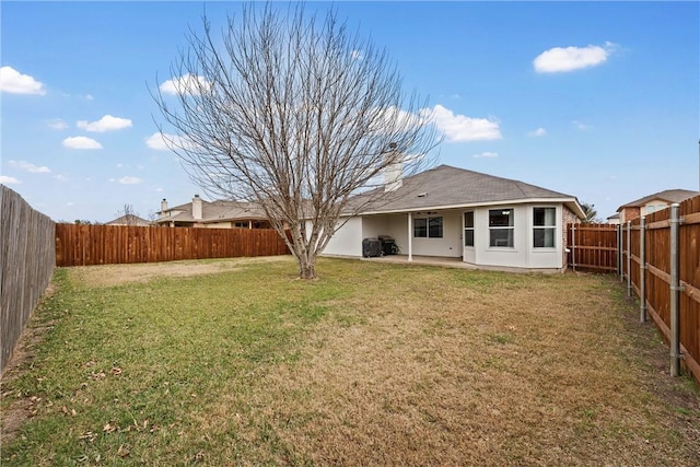 rear view of property featuring a yard and a patio area