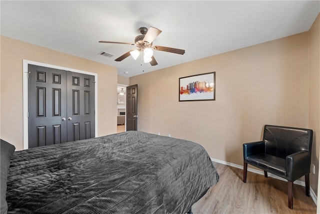 bedroom featuring light wood-type flooring, ceiling fan, and a closet