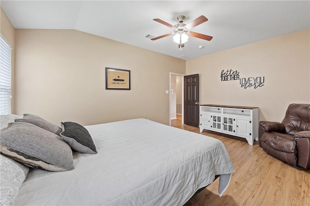 bedroom featuring ceiling fan, vaulted ceiling, and light hardwood / wood-style flooring