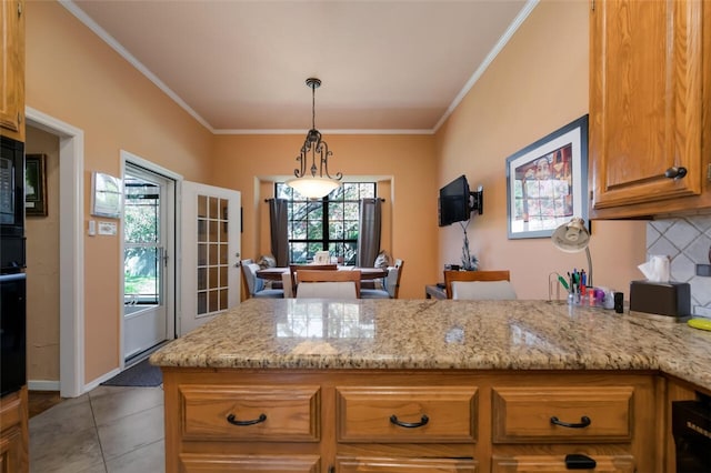 kitchen with hanging light fixtures, light stone counters, decorative backsplash, light tile patterned flooring, and ornamental molding