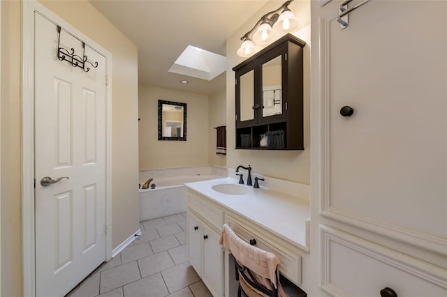 bathroom with tile patterned floors, vanity, a washtub, and a skylight