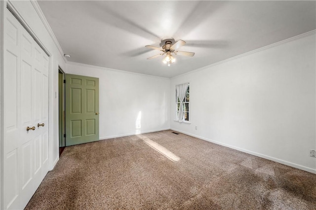 empty room featuring crown molding, carpet, and ceiling fan