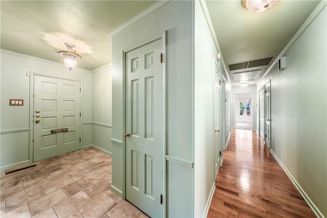 corridor with light hardwood / wood-style flooring and crown molding