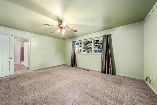 carpeted empty room with ceiling fan and crown molding