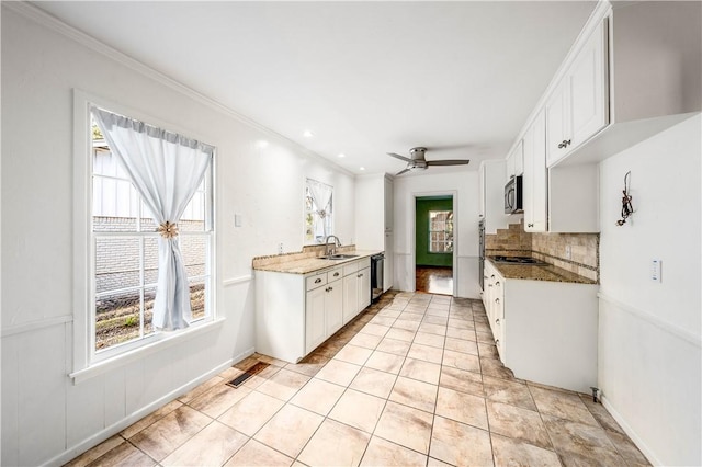 kitchen featuring ceiling fan, sink, black dishwasher, dark stone counters, and white cabinets