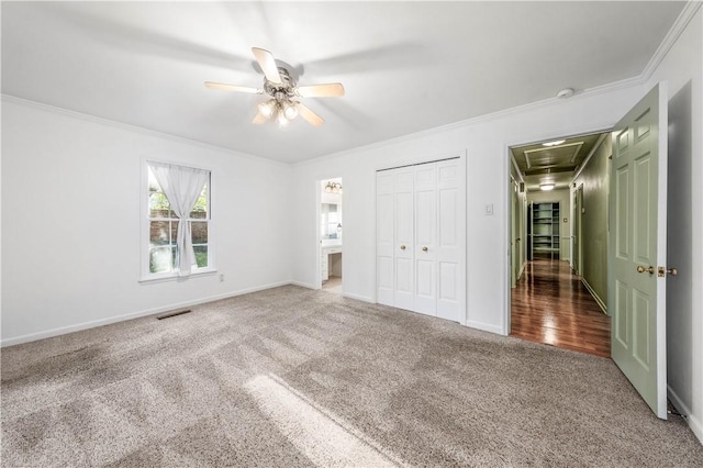 unfurnished bedroom featuring carpet, a closet, ceiling fan, and crown molding