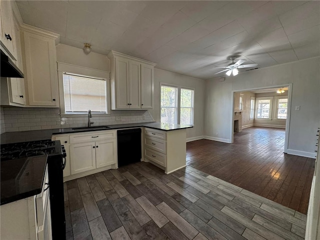 kitchen featuring sink, dark wood-type flooring, tasteful backsplash, white cabinets, and black appliances