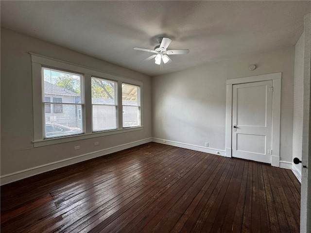 empty room with ceiling fan and dark wood-type flooring