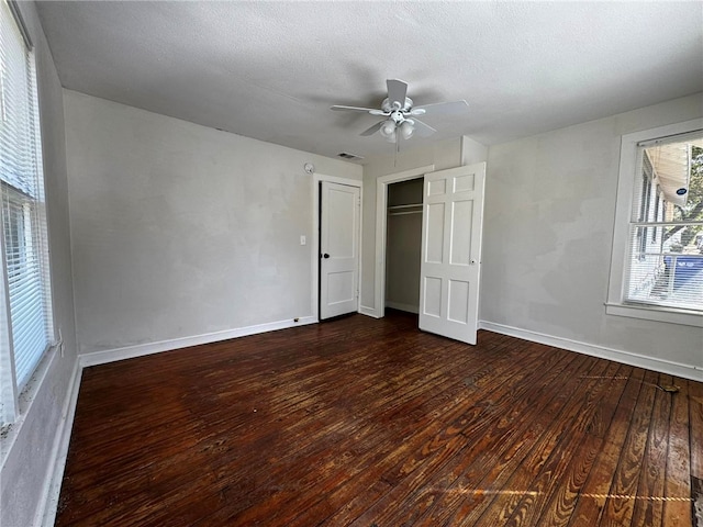 unfurnished bedroom with a textured ceiling, ceiling fan, and dark wood-type flooring