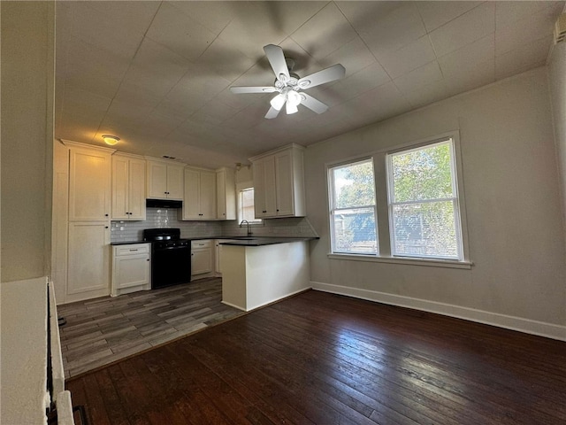 kitchen with black range, dark hardwood / wood-style floors, and white cabinetry