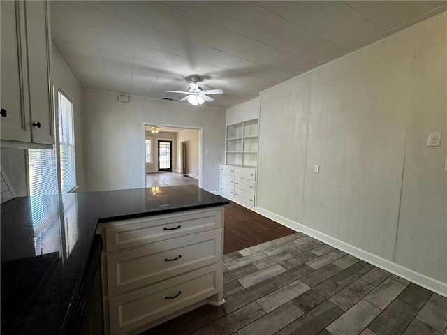 kitchen featuring kitchen peninsula, white cabinetry, dark hardwood / wood-style flooring, and ceiling fan