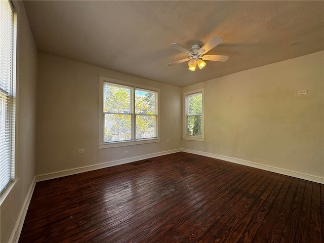 spare room with a textured ceiling, ceiling fan, and dark hardwood / wood-style floors