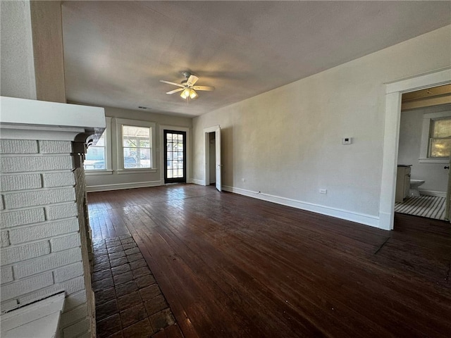 unfurnished living room featuring dark hardwood / wood-style flooring, a brick fireplace, and ceiling fan