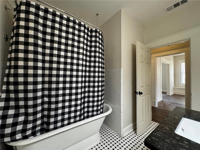 bathroom with tile patterned floors, shower / bath combination with curtain, and sink