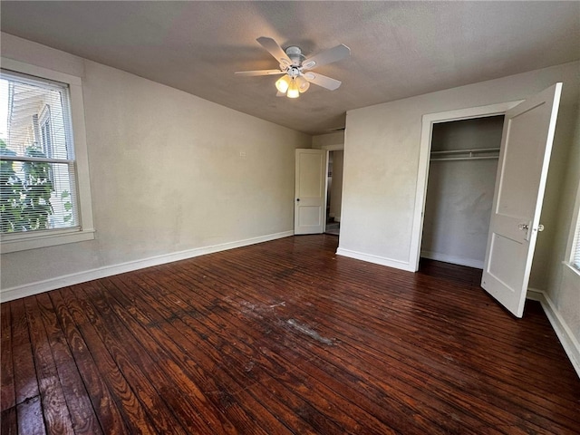 unfurnished bedroom with ceiling fan, dark wood-type flooring, lofted ceiling, a textured ceiling, and a closet