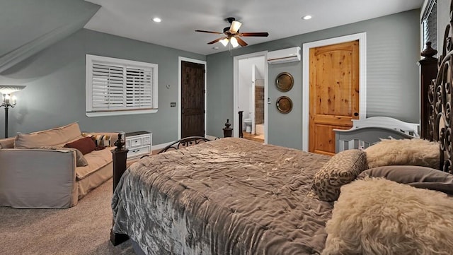 carpeted bedroom featuring ceiling fan, ensuite bathroom, and a wall mounted air conditioner