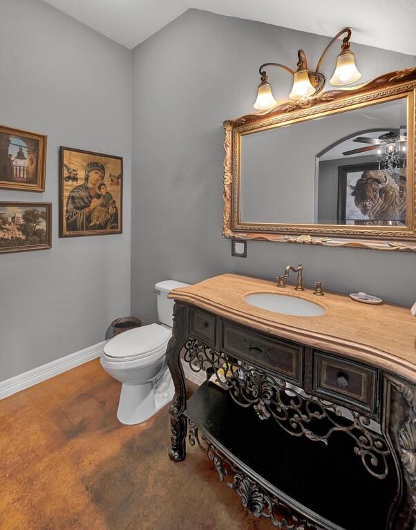 bathroom with vanity, toilet, and vaulted ceiling