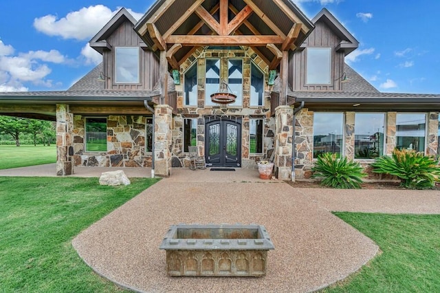 entrance to property featuring french doors and a lawn