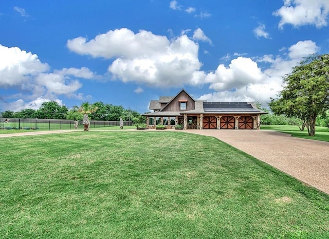 view of front of house with solar panels, a rural view, and a front lawn