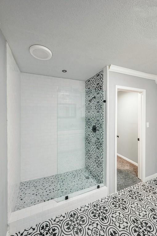 bathroom featuring tiled shower, a textured ceiling, and ornamental molding