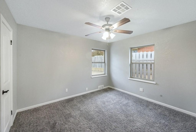 empty room featuring ceiling fan and carpet