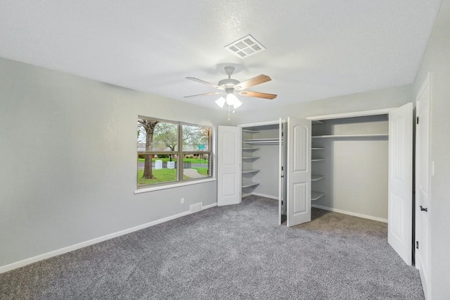 unfurnished bedroom with multiple closets, ceiling fan, and carpet