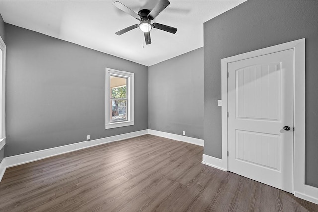 spare room featuring dark hardwood / wood-style flooring and ceiling fan