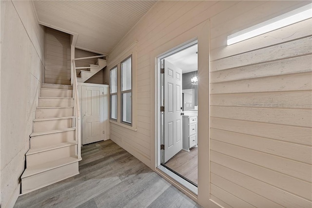 interior space featuring wood-type flooring and wooden walls