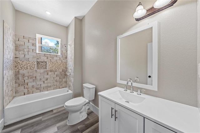 full bathroom with vanity, wood-type flooring, tiled shower / bath combo, and toilet