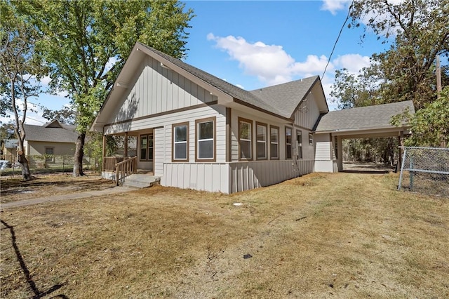 view of side of home with a carport and a yard