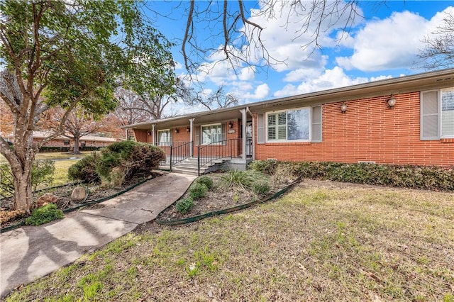 single story home featuring covered porch and a front yard