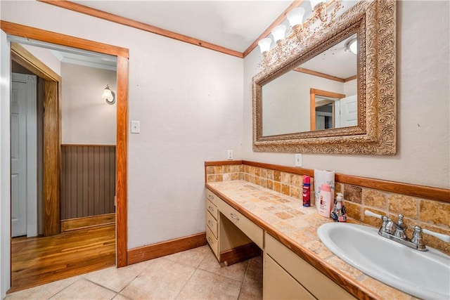 bathroom with tile patterned flooring, crown molding, and vanity