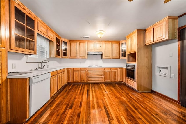 kitchen with sink, dark wood-type flooring, black oven, white dishwasher, and gas stovetop