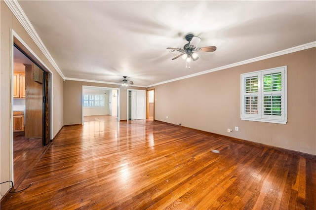 spare room with hardwood / wood-style flooring, crown molding, and ceiling fan