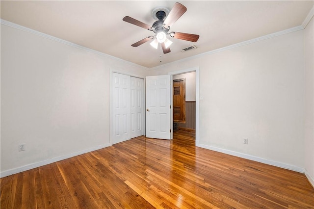 unfurnished bedroom with ceiling fan, ornamental molding, and wood-type flooring