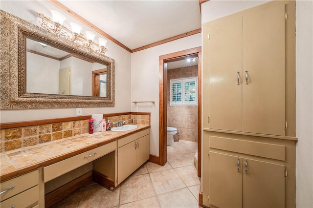 bathroom featuring vanity, tile patterned flooring, crown molding, and toilet