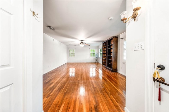 unfurnished living room featuring ceiling fan and wood-type flooring