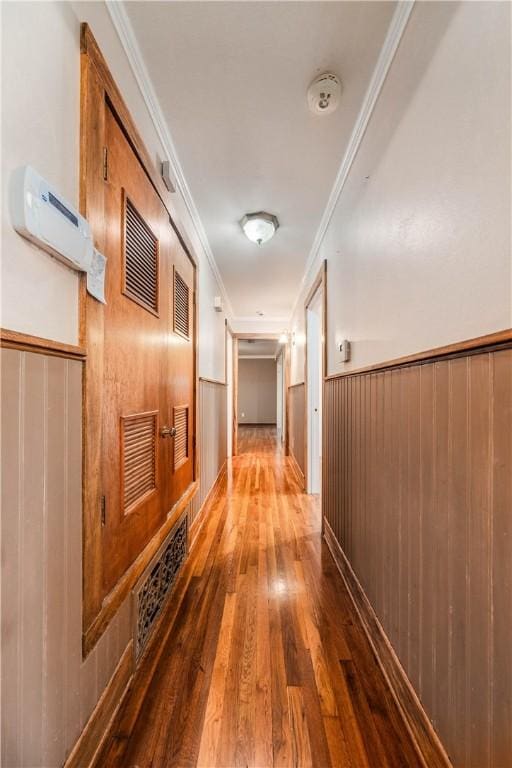 corridor with crown molding, dark wood-type flooring, and wood walls