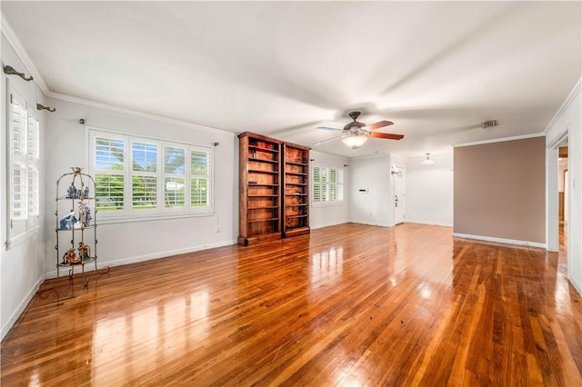 unfurnished living room with hardwood / wood-style flooring, ornamental molding, and a healthy amount of sunlight