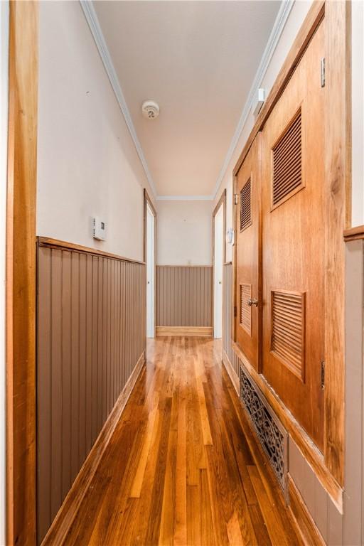 corridor featuring hardwood / wood-style flooring and ornamental molding