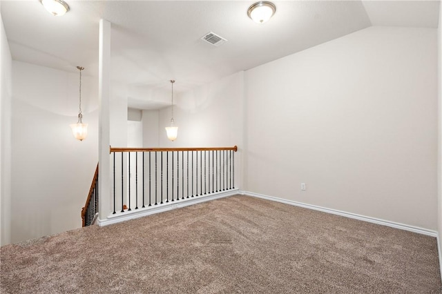 carpeted empty room featuring lofted ceiling