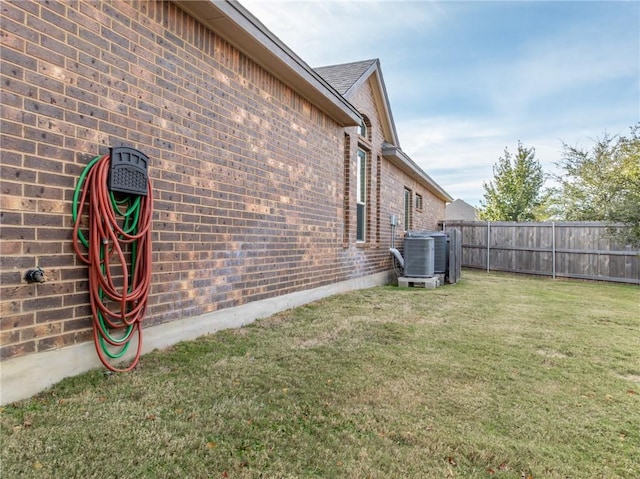 view of home's exterior featuring central AC unit and a lawn