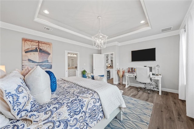 bedroom with wood-type flooring, ensuite bathroom, a raised ceiling, and crown molding